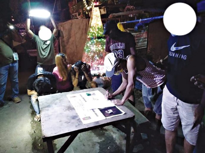 Mary Grace Lopez, 26; Rommel Aropio, 39; and Tyron Bellosillo, 30, sit handcuffed while antidrug operatives conduct an inventory of shabu seized in an entrapment in Barangay 1, Bacolod City on Dec. 30. BCPO Mary Grace Lopez, 26; Rommel Aropio, 39; and Tyron Bellosillo, 30, sit handcuffed while antidrug operatives conduct an inventory of shabu seized in an entrapment in Barangay 1, Bacolod City on Dec. 30. BCPO