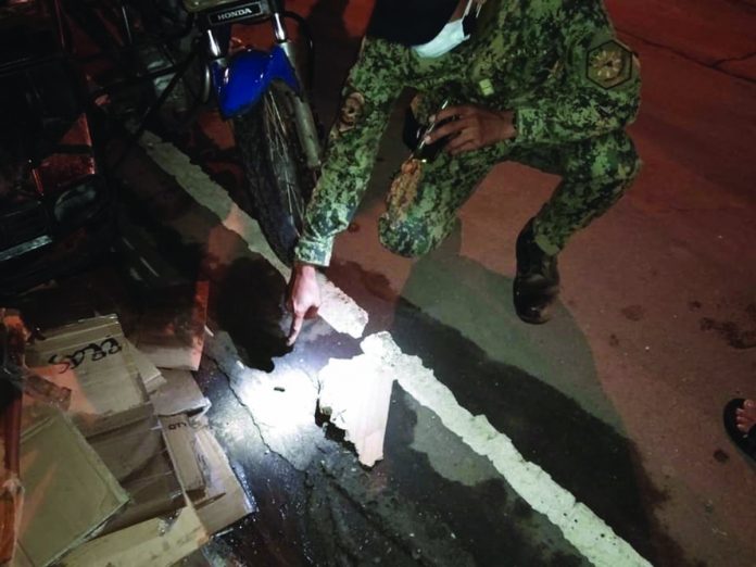 Metro pic A police officer points to a spent bullets of a .45-caliber gun recovered after a shooting incident on Rizal Street, Barangay 9, Kabankalan City, Negros Occidental on Dec. 11. CONTRIBUTED PHOTO