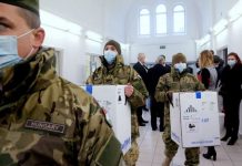Hungarian soldiers carry the first shipment of Pfizer-BioNTech COVID-19 vaccines at the Del-Pest Central Hospital in Budapest, Hungary on Dec. 26, 2020. SZILARD KOSZTICSAK/POOL VIA REUTERS/FILE