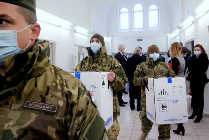 Hungarian soldiers carry the first shipment of Pfizer-BioNTech COVID-19 vaccines at the Del-Pest Central Hospital in Budapest, Hungary on Dec. 26, 2020. SZILARD KOSZTICSAK/POOL VIA REUTERS/FILE Hungarian soldiers carry the first shipment of Pfizer-BioNTech COVID-19 vaccines at the Del-Pest Central Hospital in Budapest, Hungary on Dec. 26, 2020. SZILARD KOSZTICSAK/POOL VIA REUTERS/FILE