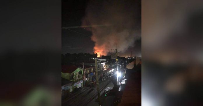 Smoke and flames billow from houses razed by fire in Barangay Monica Blumintritt, Iloilo City around 10 p.m. on Dec. 21. IAN PAUL CORDERO/PN