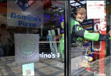 A man leaves as ‘halal’ logo of Indonesian Ulema Council is displayed on the facade of a restaurant in Jakarta, Indonesia. TATAN SYUFLANA/AP PHOTO