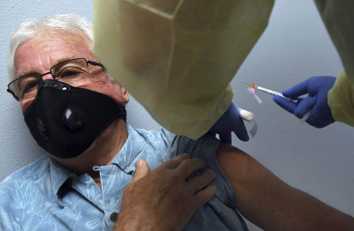 nation A participant gets a shot during a COVID-19 vaccine clinical trial sponsored by Moderna. PAUL HENNESSY/AP