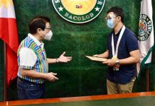 Bacolod fetes PLE topnotcher Mayor Evelio Leonardia (left) of Bacolod City hands over a framed copy of his executive order to Patrick Joseph Mabugat (right) congratulating the latter for ranking No. 2 in the 2020 Physician Licensure Examination. BACOLOD CITY PIO