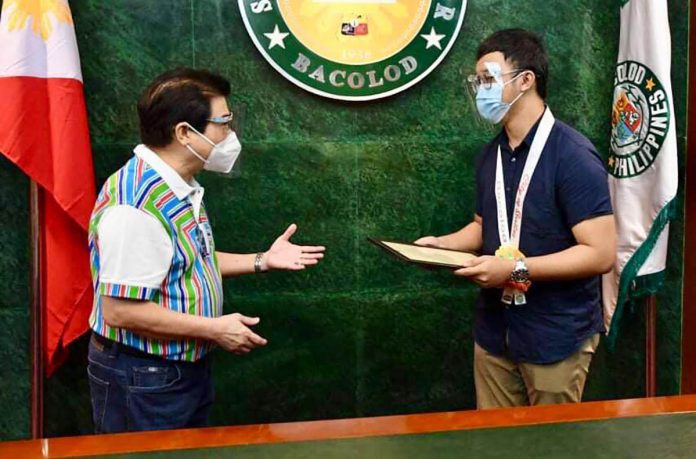 Mayor Evelio Leonardia (left) of Bacolod City hands over a framed copy of his executive order to Patrick Joseph Mabugat (right) congratulating the latter for ranking No. 2 in the 2020 Physician Licensure Examination. BACOLOD CITY PIO Mayor Evelio Leonardia (left) of Bacolod City hands over a framed copy of his executive order to Patrick Joseph Mabugat (right) congratulating the latter for ranking No. 2 in the 2020 Physician Licensure Examination. BACOLOD CITY PIO