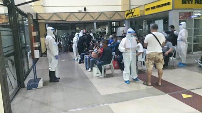 Frontline workers tend to repatriated residents at the Bacolod-Silay Airport in Silay City, Negros Occidental. Half of the 32 local government units in the province imposed a moratorium on the arrival of locally stranded individuals during the holiday season. BACOLOD DRRMO