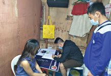 Drug suspect Baby Girl Villarna sits handcuffed while antidrug operatives conduct an inventory of suspected shabu seized in a buy-bust operation in Barangay 2 on Jan. 28. BCPO