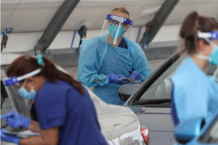 Medical workers administer tests at the Bondi Beach drive-through COVID-19 testing center in the wake of an outbreak in Sydney, Australia on Dec. 22, 2020. LOREN ELLIOTT/REUTERS Medical workers administer tests at the Bondi Beach drive-through COVID-19 testing center in the wake of an outbreak in Sydney, Australia on Dec. 22, 2020. LOREN ELLIOTT/REUTERS