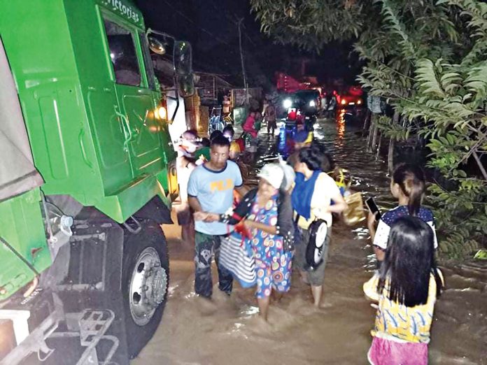 flood-hits-negros WET START FOR 2021. Police officers assist residents seeking evacuation after flashfloods hit 12 villages in Victorias City, Negros Occidental on New Year’s Eve. Thousands were forced to flee their inundated homes as torrential rain triggered floods in some parts of the province. CONTRIBUTED PHOTO
