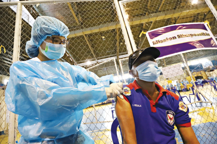 mock-vaccination PRACTICE. A health worker injects an “anti-coronavirus vaccine” to a personnel of the Iloilo City government’s Public Safety and Transportation Management Office during a mock vaccination yesterday, Jan. 29, 2021. ARNOLD ALMACEN/CMO