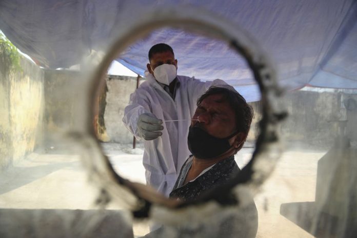 A health worker takes a nasal swab sample at a COVID-19 testing center in Hyderabad, India on Jan. 2, 2021. MAHESH KUMAR A./AP PHOTO A health worker takes a nasal swab sample at a COVID-19 testing center in Hyderabad, India on Jan. 2, 2021. MAHESH KUMAR A./AP PHOTO