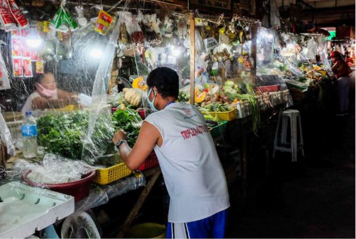 Stall owners install plastic barriers and encourage physical distancing at the Las Piñas City public market on March 31, 2020. GEORGE CALVELO/ABS-CBN NEWS Stall owners install plastic barriers and encourage physical distancing at the Las Piñas City public market on March 31, 2020. GEORGE CALVELO/ABS-CBN NEWS