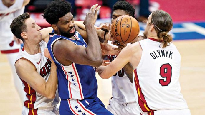 Philadelphia 76ers’ Joel Embiid is clobbered by the defense of three Miami Heat players. AP PHOTO Philadelphia 76ers’ Joel Embiid is clobbered by the defense of three Miami Heat players. AP PHOTO