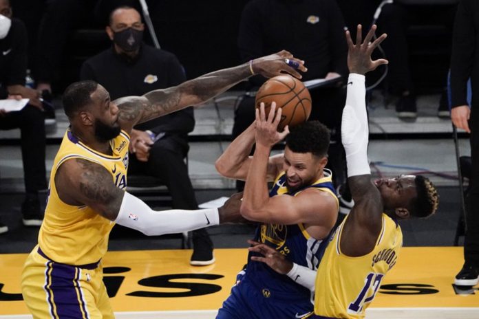Los Angeles Lakers’ LeBron James and Dennis Schroder defend against Golden State Warriors’ Stephen Curry during the second half of an NBA basketball game on Jan. 18, 2021. JAE C. HONG/AP PHOTO Los Angeles Lakers’ LeBron James and Dennis Schroder defend against Golden State Warriors’ Stephen Curry during the second half of an NBA basketball game on Jan. 18, 2021. JAE C. HONG/AP PHOTO