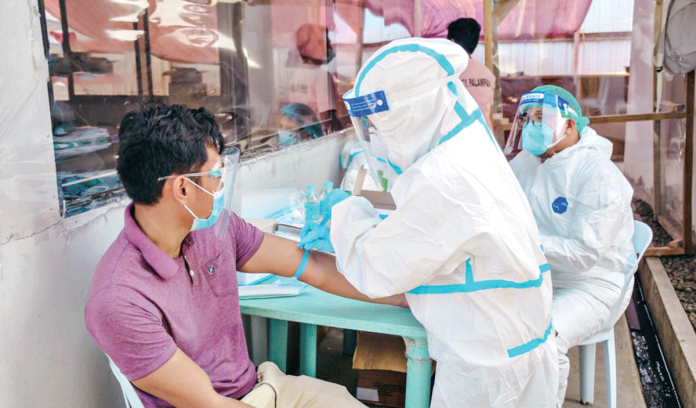 A healthcare worker collects blood specimens from a job order employee during the coronavirus surveillance testing in San Carlos City, Negros Occidental. SAN CARLOS CITY PIO A healthcare worker collects blood specimens from a job order employee during the coronavirus surveillance testing in San Carlos City, Negros Occidental. SAN CARLOS CITY PIO