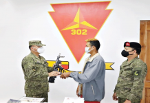 ‘NPA squad leader’ yields to Negros Army PH ARMY’S 302IB Rebel returnee Jerryd Gargoles turns over a pistol to Colonel Leonardo Pena, commander of the Philippine Army’s 302nd Infantry Brigade in a ceremony in Himalayan City, Negros Occidental.