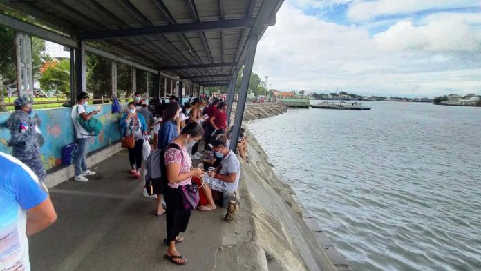 region-guimaras-byahe-pic These Guimaras-bound people want to cross the Iloilo Strait but there are no motorboats to transport them at the Iloilo Ferry Terminal-Parola in Iloilo City. Wooden-hulled boats have been grounded by the Maritime Industry Authority. IAN PAUL CORDERO/PN