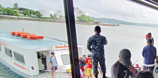 A policeman watches as boatmen prepare this Guimaras-bound fiberglass motorboat at the Iloilo Ferry Terminal-Parola in Iloilo City. IAN PAUL CORDERO/PN