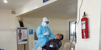 A Kalibo International Airport security personnel gets ready to be swabbed. His specimen would then be analyzed for the possible presence of the coronavirus disease 2019 virus. PHOTO BY THE KALIBO AIRPORT PNP