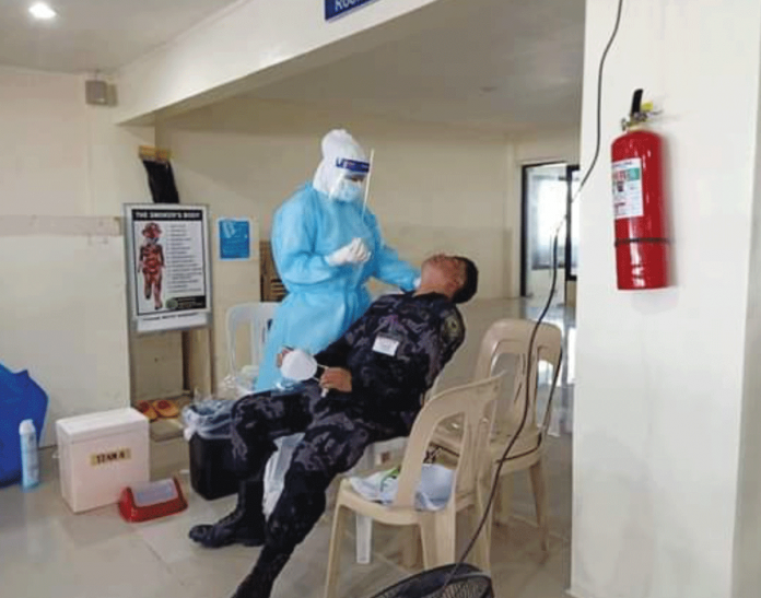 A Kalibo International Airport security personnel gets ready to be swabbed. His specimen would then be analyzed for the possible presence of the coronavirus disease 2019 virus. PHOTO BY THE KALIBO AIRPORT PNP A Kalibo International Airport security personnel gets ready to be swabbed. His specimen would then be analyzed for the possible presence of the coronavirus disease 2019 virus. PHOTO BY THE KALIBO AIRPORT PNP