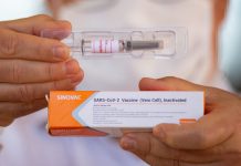 A professor at the University of Brasilia shows the vaccine to journalists amidst the coronavirus pandemic on Aug. 5, 2020 in Brazil. ANDRESSA ANHOLETE/GETTY IMAGES