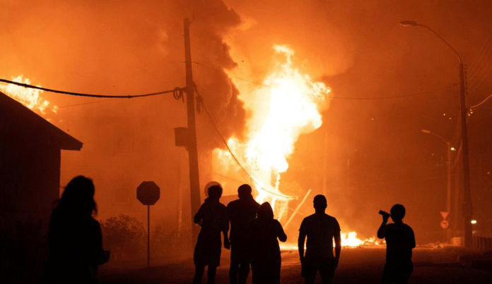 Chile Protesters set a public building on fire after a police officer shot and killed a street performer in Panguipulli on Feb. 5. ANDRES QUEZADA/REUTERS