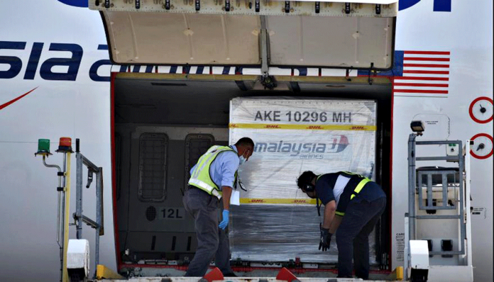 Malaysia-to-start Containers carrying the first batch of Pfizer-BioNTech coronavirus disease 2019 vaccines are unloaded from a plane at the MASkargo Complex in Sepang, Malaysia on Feb. 21, 2021. MALAYSIA INFORMATION DEPARTMENT/FANDY AZLAN/HANDOUT VIA REUTERS