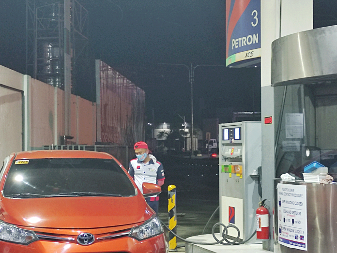 Oil-firms-set-to-hike-prices-anew A gasoline boy fills the tank of a vehicle on Monday night. Oil firms impose again increases in their pump prices effective today. PN PHOTO