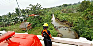 FLOOD WATCH. As a precautionary measure, this personnel of the Bureau of Fire Protection monitors the water level of this river in Balasan, Iloilo from a bridge. Typhoon “Auring” is expected to hit the northern tip of Iloilo province. BALASAN BFP