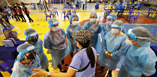 ‘VACCINE HUDDLE’ Almost unrecognizable behind their masks, scrubs, gloves, and hairnet, health workers listen to instructions from a personnel of the Iloilo City Health Office during a mock coronavirus vaccination. These frontliners are the top priority in the government’s immunization program. ARNOLD ALMACEN/CMO