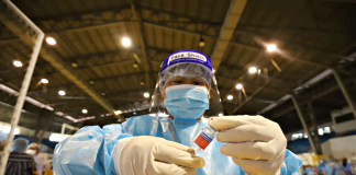 ANTI-COVID DOSE. A health worker prepares an “anti-coronavirus vaccine” during a mock vaccination in Iloilo City on Jan. 29. Based on the city government’s initial immunization screening, Ilonggos are hesitant to get the shots due to the potential side effects. ARNOLD ALMACEN/CMO