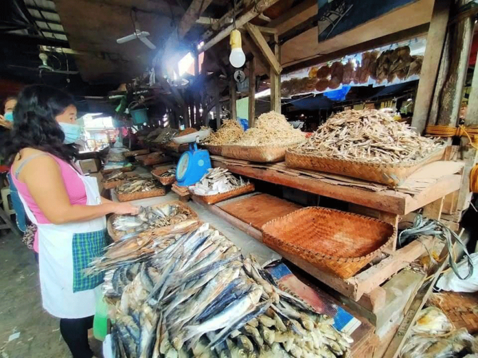 Wearing facemask, this vendor tends to her dried fish products inside the public market of Passi City. After two days of lockdown due to a surge in coronavirus cases, the public market reopened on Jan. 31. PASSI CITY LGU