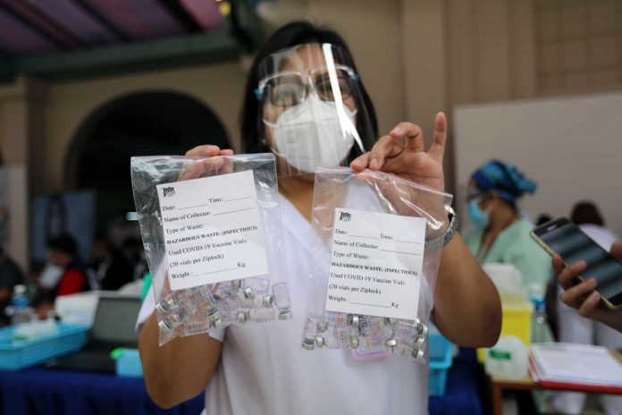 AstraZeneca A health worker shows empty vials of CoronaVac during the vaccination of frontline healthcare workers at the University of the Philippines-Philippine General Hospital on Monday. PNA/JOEY O. RAZON