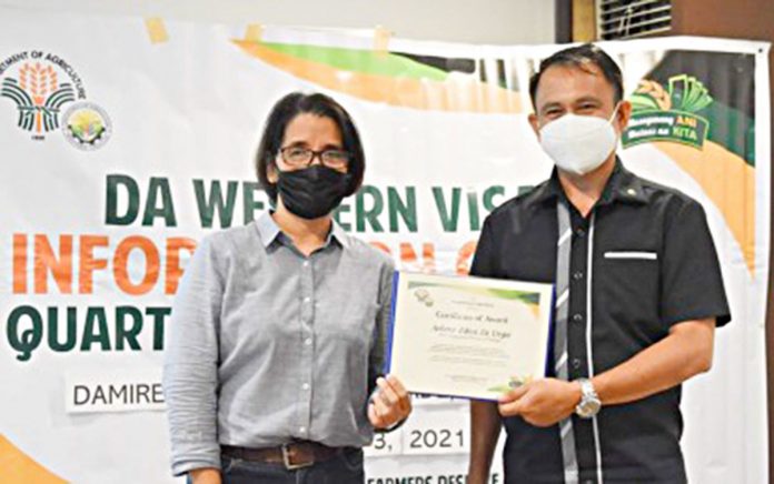 Office of Provincial Agriculture Antique farm-caster Arlene Edna La Vega (left) receives an award for having established the most number of Barangay Agriculture Information Centers in Western Visayas from the Department of Agriculture (DA) regional information officer James Earl Ogatis (right) during the 1st Quarter DA Family Information Officers’ Meeting on March 2 and 3 in Janiuay, Iloilo. OPA ANTIQUE