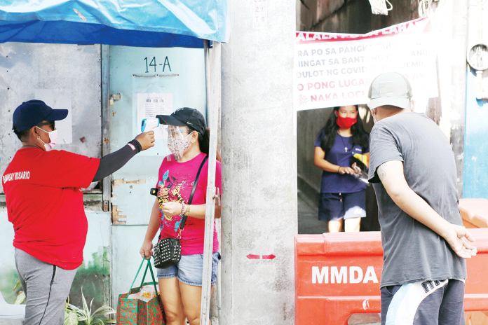 COVID A barangay personnel checks the body temperature of a resident at a quarantine checkpoint. Presidential spokesperson Harry Roque said the Inter-Agency Task Force on the Management of Emerging Infectious Diseases should not be blamed for the mutation of coronavirus disease 2019 in the country. PNA/JOEY O. RAZON