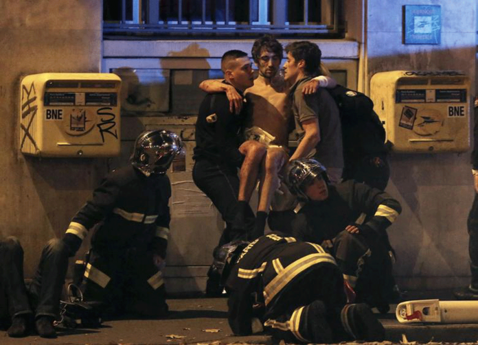 Italy-news French fire brigade members aid an injured individual near the Bataclan concert hall following fatal shootings in Paris, France on Nov. 13, 2015. REUTERS/CHRISTIAN HARTMANN