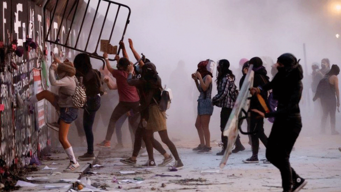 Mexico-City Some protesters try to break through a metal barrier that had been erected ahead of the march. On Monday, police and activists have clashed in Mexico City at a march to mark International Women’s Day. REUTERS