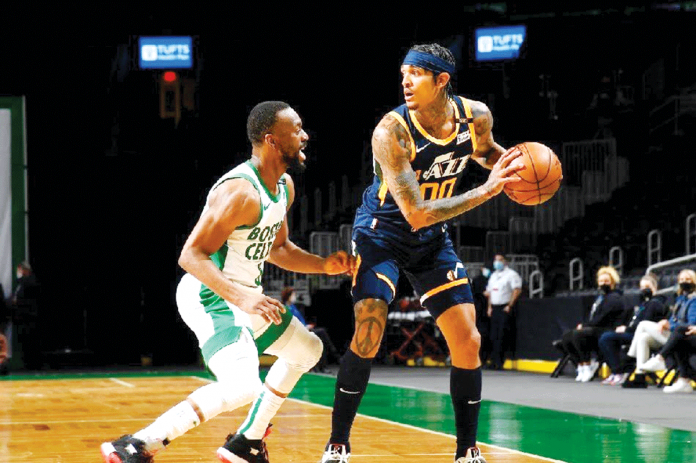 NBA Filipino-American guard Jordan Clarkson (right) of Utah Jazz protects the ball while being barricaded by Boston Celtics' Kemba Walker (left) during their 2020-2021 NBA Season game at the TD Garden in Boston, Massachusetts. BRIAN BABINEAU/GETTY IMAGES