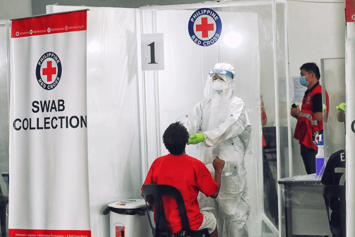 Nation-1 A staff from the Philippine Red Cross conducts swab test. The Philippine Health Insurance Corporation owes the Philippine Red Cross P822 million for coronavirus disease 2019 tests. IFRC