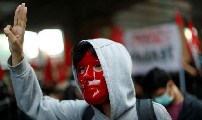 Thailand-protest-2 A masked anti-government protester shows the three-finger salute while marching in a protest demanding the release of arrested leaders charged with lese majeste law in Bangkok, Thailand on March 6, 2021. REUTERS/JORGE SILVA