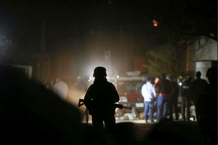 Truck-borne-gunmen-kill-11-in A soldier guards the area where 11 people were killed when unidentified gunmen riding in a truck opened fire in Tonala, State of Jalisco, Mexico on Feb. 27, 2021. REUTERS/FERNADO CARRANZA