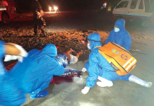 Authorities inspect the body of one of the two men who died in a road accident in Barangay Cabug, Bacolod City on March 21. BCPO