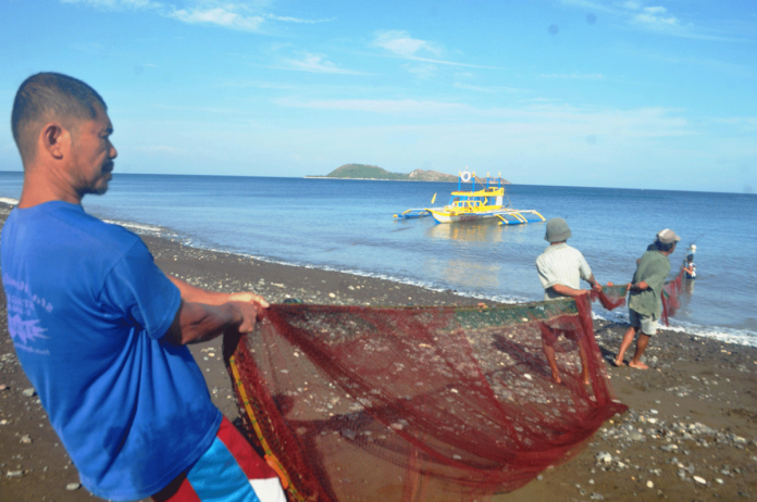 region-antique-coastal Hoping for a bountiful catch, these fishermen in Culasi, Antique help one another pull a fishnet to the shore. Locals call this panahid (beach seining). A typical beach seine has weights attached to the leadline at the bottom of the net and buoys or floats attached to the floatline at the top of the net. The downward force of the weights counteracted by the buoyancy of the floats keeps the net open vertically when it is pulled through the water to entrap fish. A beach seine is often set from shore to encircle a school of fish. PN PHOTO