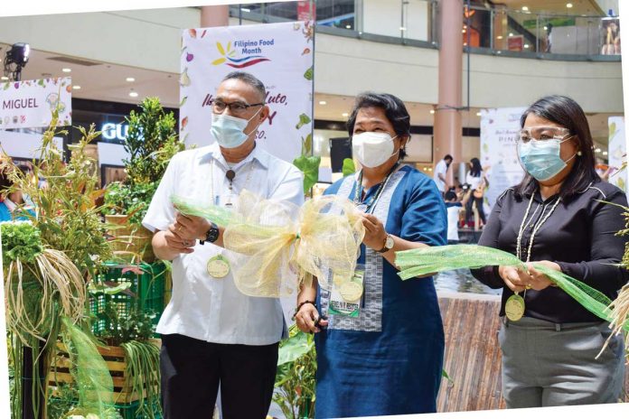Business-1-banner Department of Agriculture Western Visayas' Regional Executive Director Remelyn Recoter (center) and Iloilo City’s Agriculturist Inigo Garingalo (left) grace the opening of the one-week trade fair to mark the 2021 Filipino Food Month Celebration at Robinsons’ Place Iloilo. DA-WESTERN VISAYAS