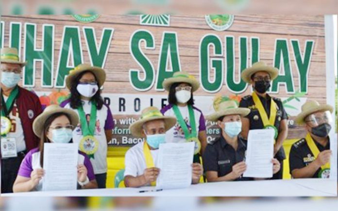 Business-1-banner Officials led by Department of Agrarian Reform-6 Regional Director Sheila Enciso (seated, left) and Senior Supt. Gilbert Peremne (seated, right), Assistant Regional Director of Bureau of Jail Management and Penology-6, attend the launching of the “Buhay sa Gulay” project in Barangay Alangilan, Bacolod City on Monday. DAR NEGROS OCCIDENTAL I-NORTH