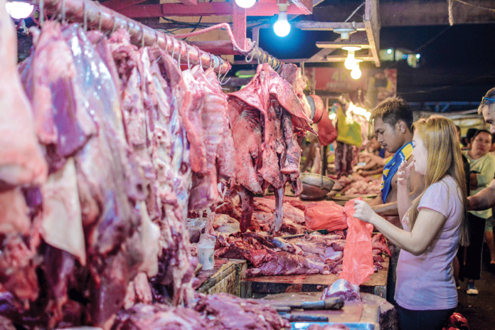 Business-2 A customer buys pork at a meat stall in Iloilo Terminal Market in Iloilo City. DA-6 Executive Regional Directors Remelyn Recoter says Western Visayas remains ASF-free. She encourages everyone to help maintain the region’s status. PANAY NEWS PHOTO