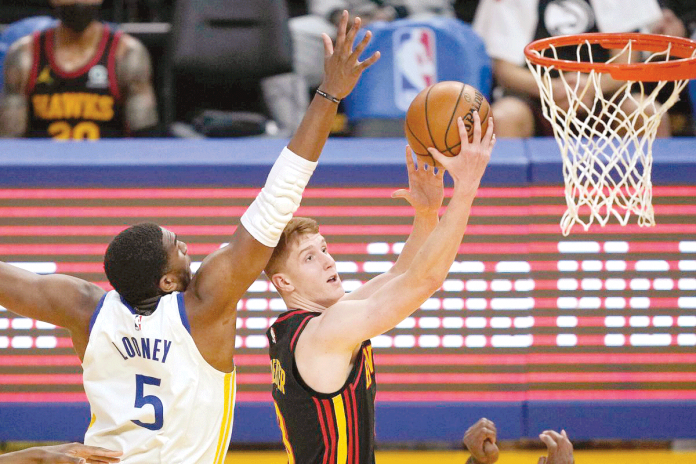Sports-1-banner Atlanta Hawks’ Kevin Huerter drives past Golden State Warriors’ Kevon Looney (5) to shoot the ball during their NBA game on Easter Sunday at State Farm Arena in Atlanta, Georgia. TONY AVELAR/AP
