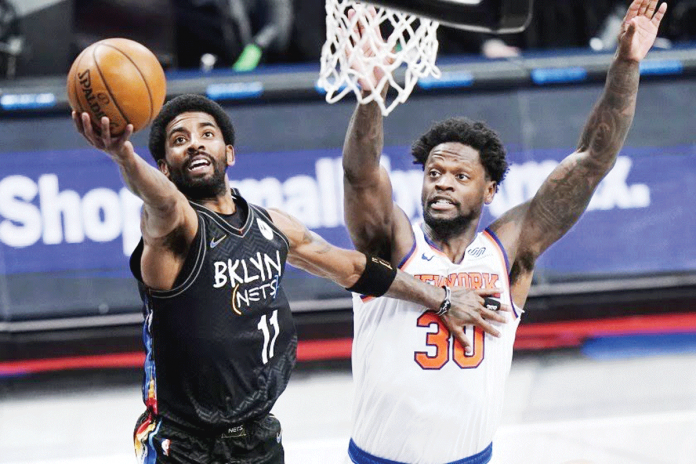Sports-3-banner Brooklyn Nets’ Kyrie Irving (11) drives past New York Knicks’ Julius Randle (30) during the first half of their NBA basketball game on Monday in New York. AP PHOTO/FRANK FRANKLIN II