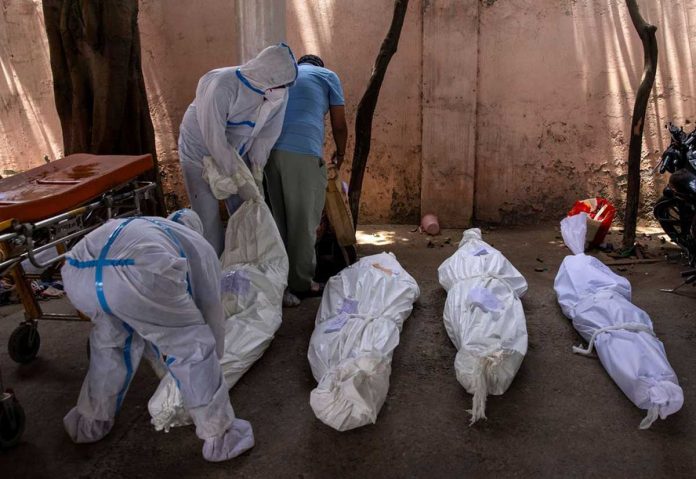 Healthcare workers place the body of a person, who died due to the coronavirus disease 2019, on the ground for cremation at a crematorium ground in New Delhi, India. REUTERS/DANISH SIDDIQUI Healthcare workers place the body of a person, who died due to the coronavirus disease 2019, on the ground for cremation at a crematorium ground in New Delhi, India. REUTERS/DANISH SIDDIQUI