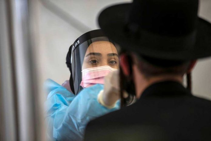 israel-covid-variant A healthcare worker takes a swab sample from an overseas returnee at Ben Gurion International Airport in Lod, Israel. The country has recorded eight cases of the virus’ Indian variant. REUTERS/RONEN ZVULUN/FILE PHOTO